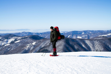 在山里徒步旅行带着背包和帐篷雪的冬天