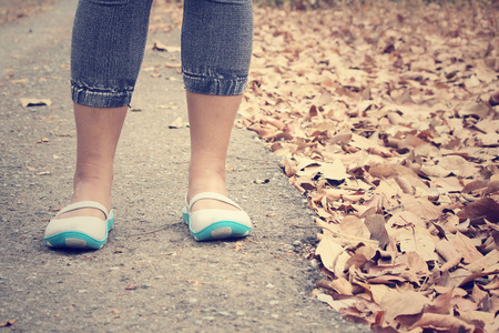 女人的鞋走在秋天的落叶
