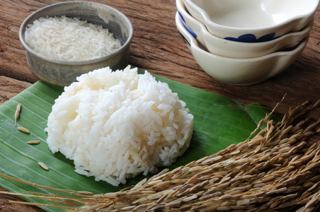 煮熟的米饭，生的米及水稻木制的桌子上