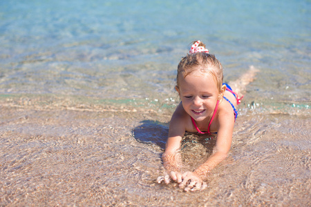 可爱的小女孩在浅水热带海滩上玩得开心