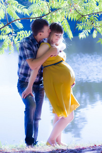 快乐和怀孕的年轻夫妇在自然
