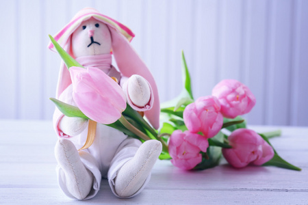 美丽的粉红色郁金香与玩具木制背景