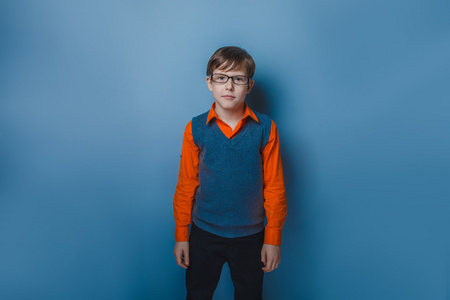 十几岁男孩戴着眼镜，穿着一件毛衣和一件衬衫，蓝色背景上