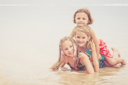 三个快乐的孩子们在沙滩上玩