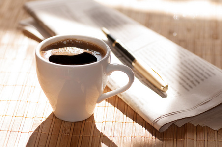 杯咖啡，报纸和一支钢笔