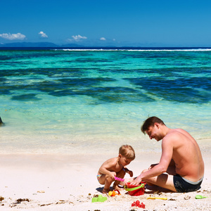 男孩和父亲在沙滩上玩