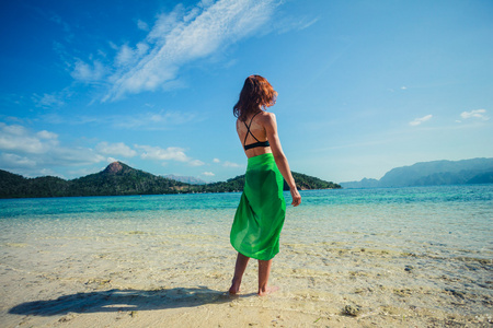 女人穿纱笼热带海滩上