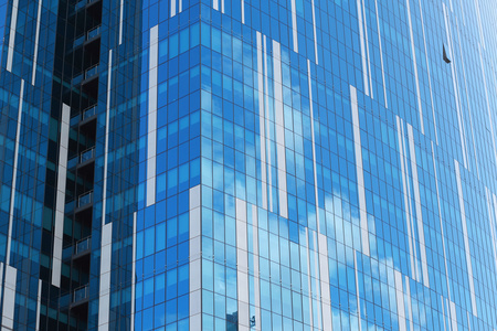 阳光明媚的日子反映云城市办公大楼的玻璃幕墙