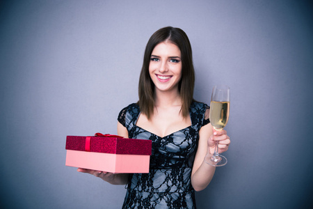 幸福的女人，拿着杯香槟及礼品盒