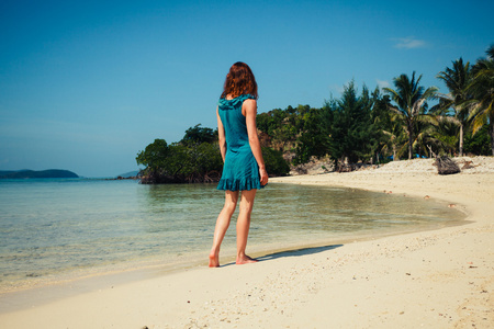 年轻女子在热带海滩上行走