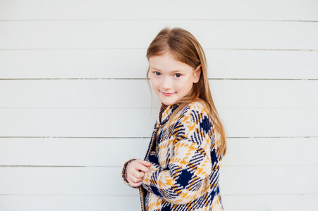 一个可爱的小女孩，穿着温暖的黄色格子衫的室外肖像