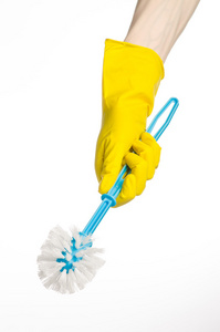 打扫房间和清洗厕所 人的手里孤立在工作室中的白色背景上的黄色防护手套拿着蓝色的马桶刷