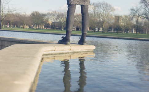 女人站在公园的喷泉旁