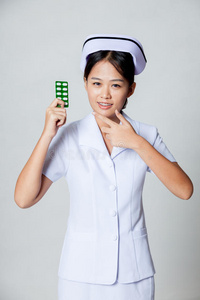 年轻的亚洲护士指着药片包