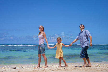 快乐的一家人在海滩散步