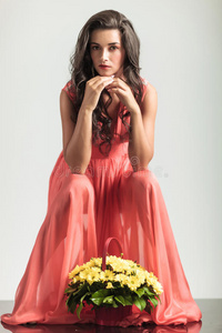 坐着的穿着红裙子的女人在花边思考