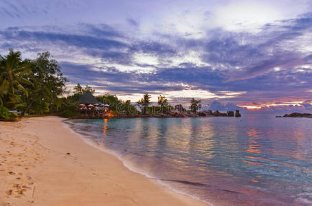 日落时塞舌尔热带海滩上的咖啡馆