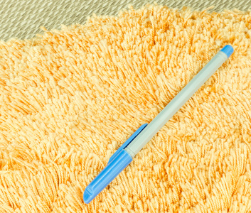 蓝色的钢笔放橙色头发毛皮地毯