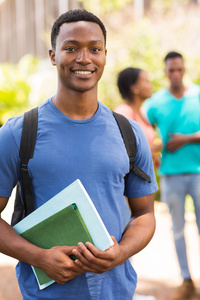 年轻的男学生拥有书籍