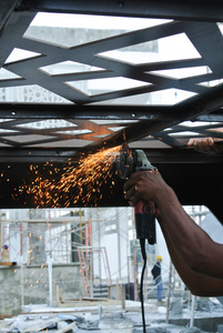 使用砂轮机切割钢铁在施工现场的建筑工人
