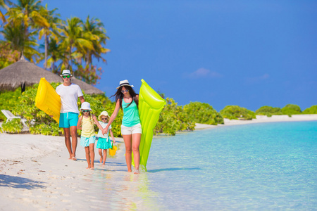 幸福美满的家庭，与空气床垫和儿童玩具的白色沙滩上
