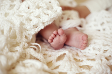 可爱的宝宝脚舒适针织毯子的照片