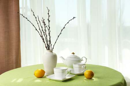 柳条 茶壶 杯和柑橘上窗帘背景表格