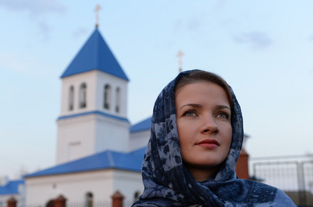 一个女孩斯拉夫俄罗斯出现在教会的背景上的一条围巾