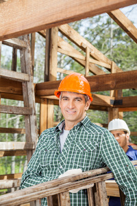微笑男建筑工人携带梯子