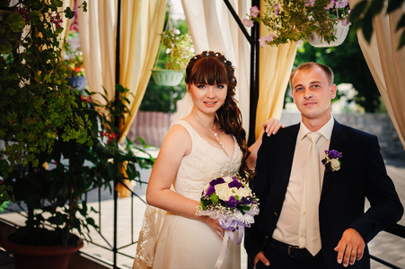 年轻的新娘和新郎在公园里，新娘的花束，婚纱礼服