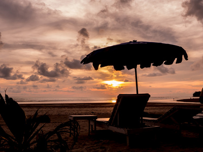 在日落时的剪影沙滩椅