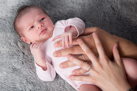 新出生的婴儿，父母手放在腹部的特写