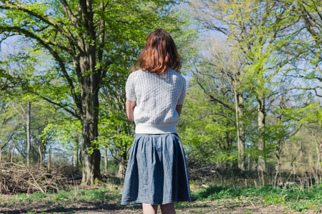 年轻女人站在一片森林