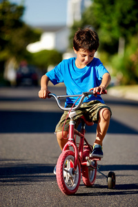 男孩学习如何向骑自行车