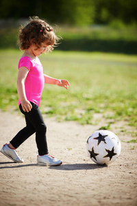 可爱的小女孩踢足球