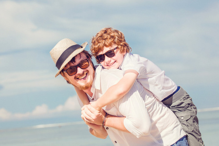 赶时髦的人父亲的胡子，红头发的儿子快乐暑假时间在晴朗的一天。友好的家庭的概念