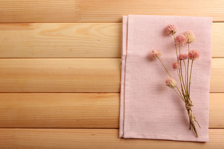 美丽的干燥花在餐巾纸上木制的背景上