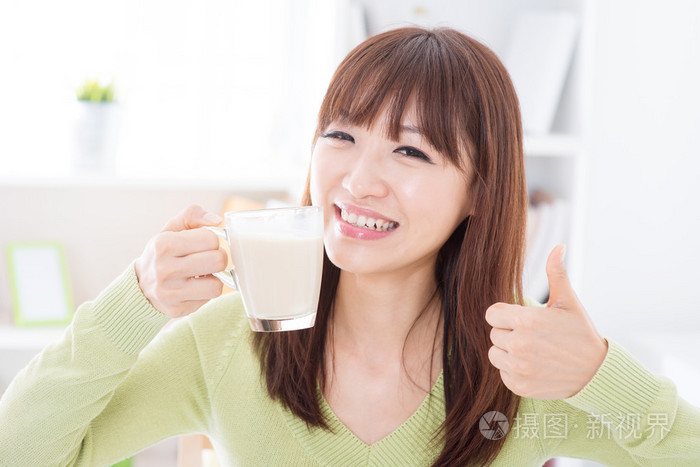 亚洲女性喝牛奶,竖起大拇指