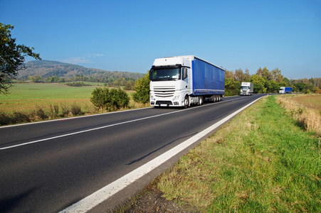 在农村的道路上的三个白色卡车