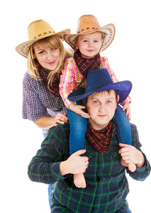快乐的年轻牛仔家庭戴着帽子爸爸妈妈和小达夫