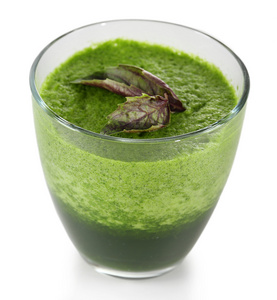 杯与罗勒上白色孤立的绿色蔬菜汁