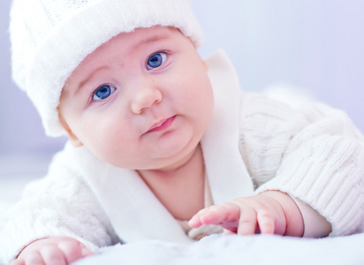 婴儿在白色的针织的服装和帽子