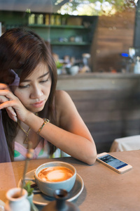 妇女生活方式使用手机在咖啡馆的咖啡厅