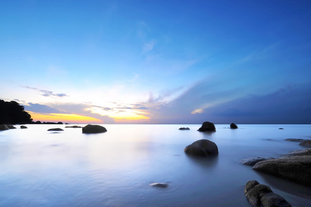 在岩石的热带海滩日出