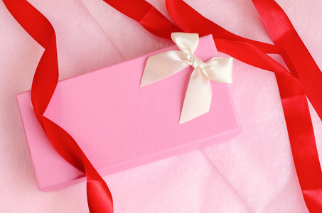 用丝带在粉红色的背景上的粉红色礼品盒