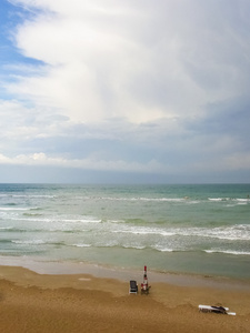夏季暴风雨期间海滩上的孤独海滩伞