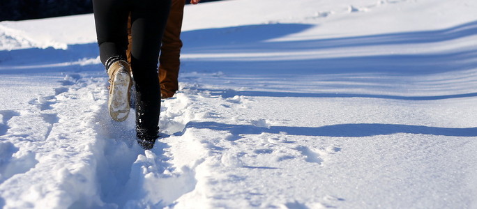 在山上的雪地上散步。雪地上的脚印复制空间