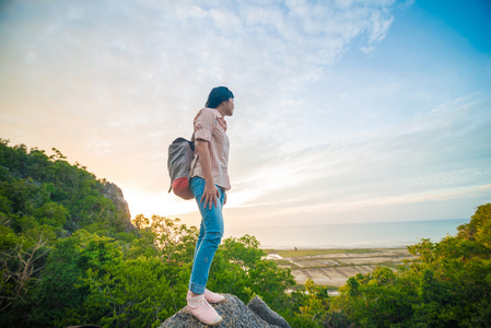 亚洲的徒步旅行者放松一座山上，背包里的女人