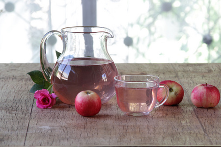在一个透明的苹果蜜饯水罐新鲜的苹果和一朵玫瑰