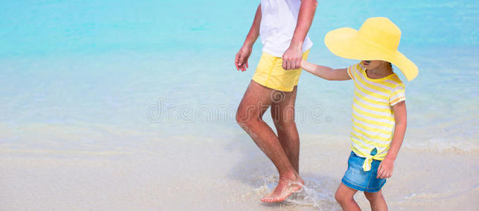 快乐的爸爸和他可爱的小女儿在海滩上